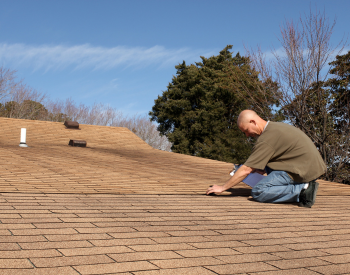 Topside Roofing contractor inspecting shingles on a Ferndale home